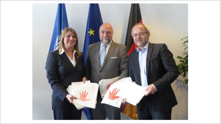 Christa Schuppler und Volkmar Klein übergeben 'rote Hände' an den Afrikabeauftragten der Bundeskanzlerin in Berlin